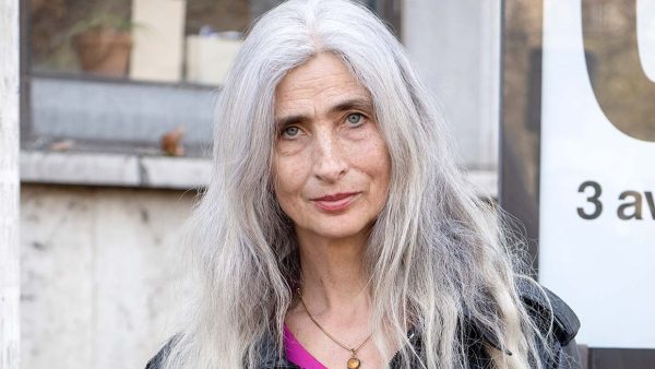 Stijlvolle vrouw met natuurlijk lang grijs haar tijdens de Paris Fashion Week. Foto Charlotte Mesman