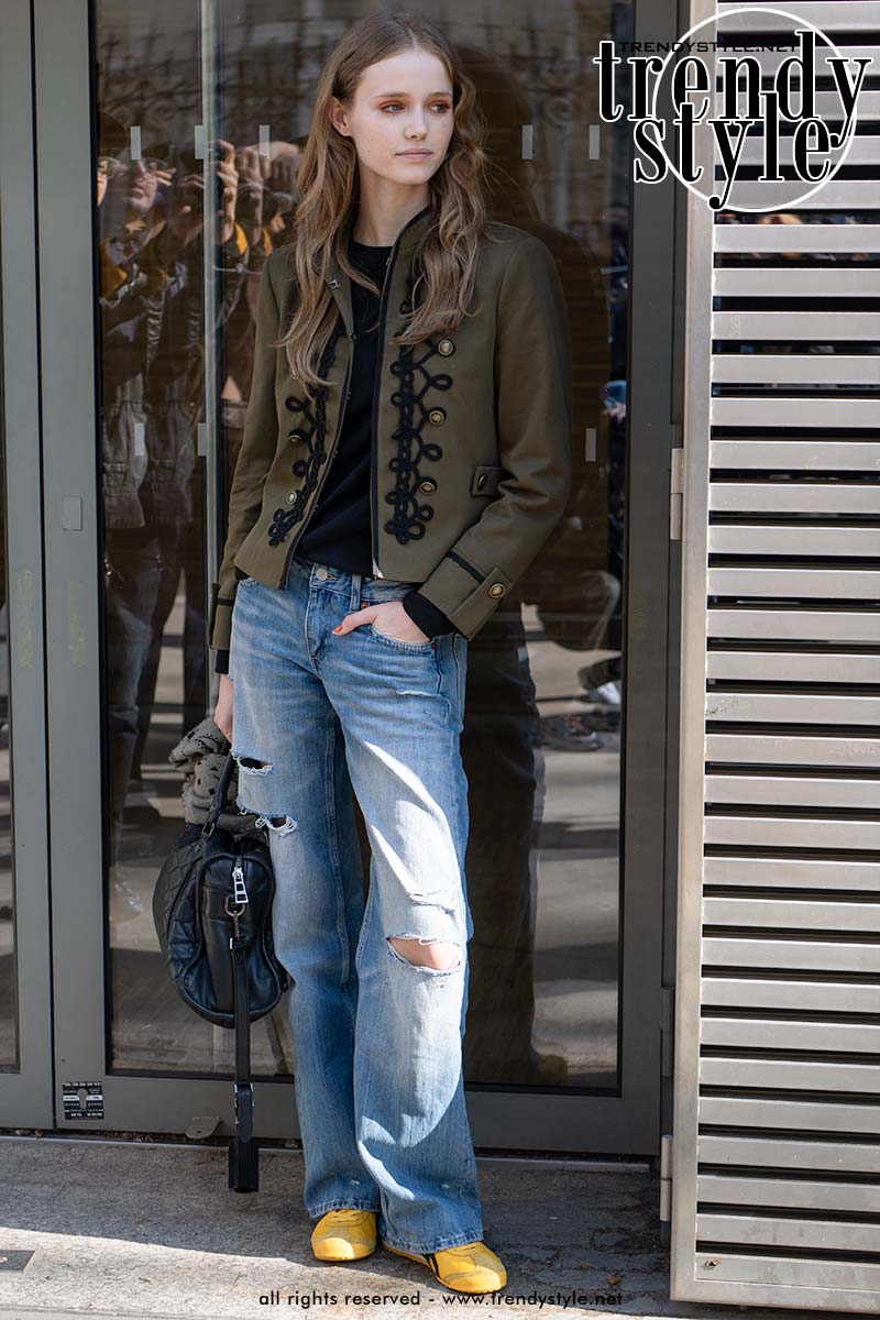 Streetstylelook met een olijfgroen militair jasje met zwarte koorddetails, gecombineerd met een ripped jeans en gele sneakers voor een moderne interpretatie van het Napoleon jacket. Foto Charlotte Mesman
