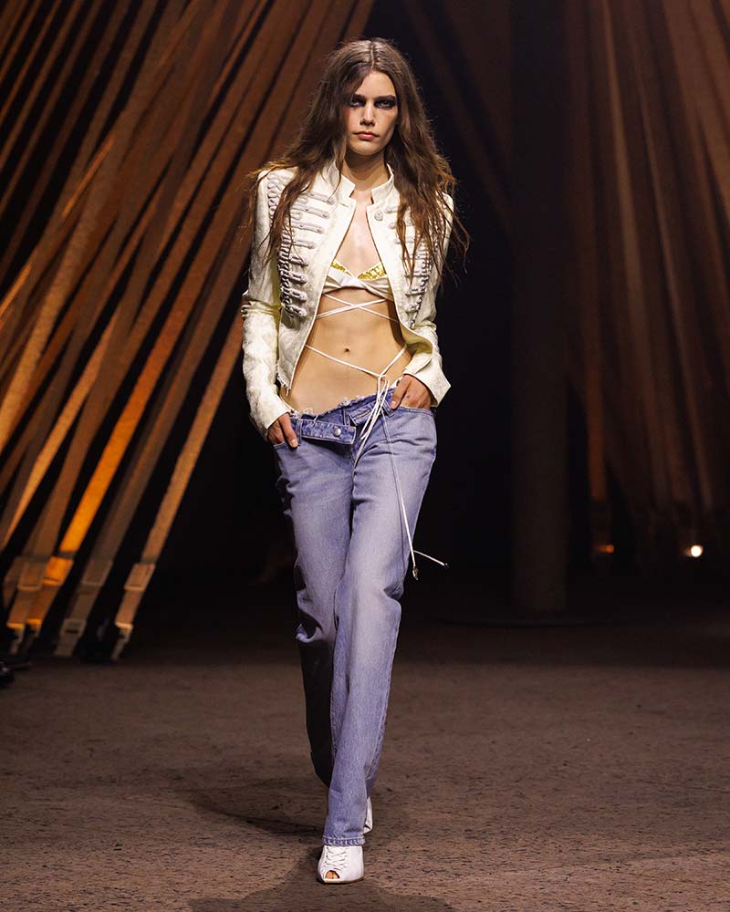 Militair jasje met slim fit spijkerbroek met lage taille op de catwalk McQueen. Photo courtesy of McQueen