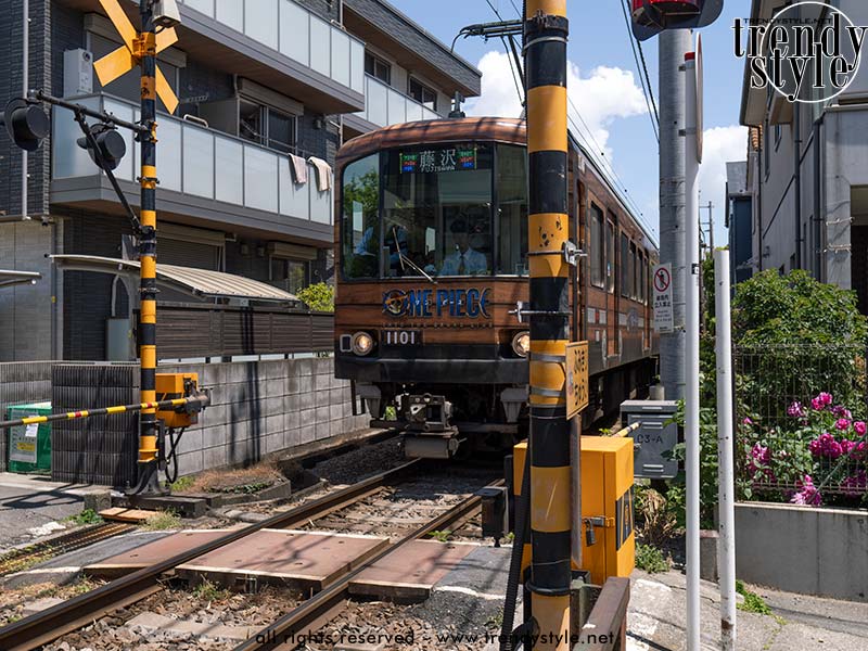 De charmante Enoden-lijn (deze trein was voor de verandering niet groen) die langs de kust en vlak langs de huizen van Kamakura gaat. Foto Charlotte Mesman
