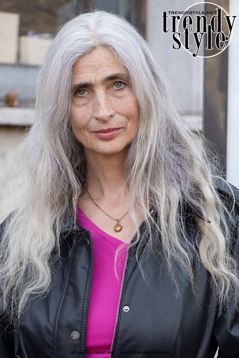 Stijlvolle gast met lang zilvergrijs haar tijdens de Paris Fashion Week – een statement look die bewijst dat grijs haar op elke leeftijd prachtig is. Foto Charlotte Mesman