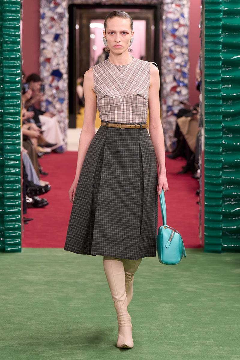 Jaren '50 rok met strakke hoge laarzen en mouwloze top. Photo courtesy of Acne Studios