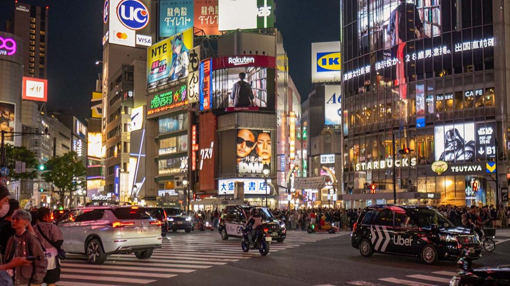 Drukke zondagavond in mei 2026 op de Shibuya Crossing in Tokio, met honderden voetgangers aan weerszijden van de zebrapaden. Foto Charlotte Mesman