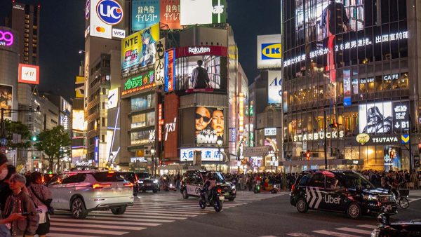 Drukke zondagavond in mei 2026 op de Shibuya Crossing in Tokio, met honderden voetgangers aan weerszijden van de zebrapaden. Foto Charlotte Mesman
