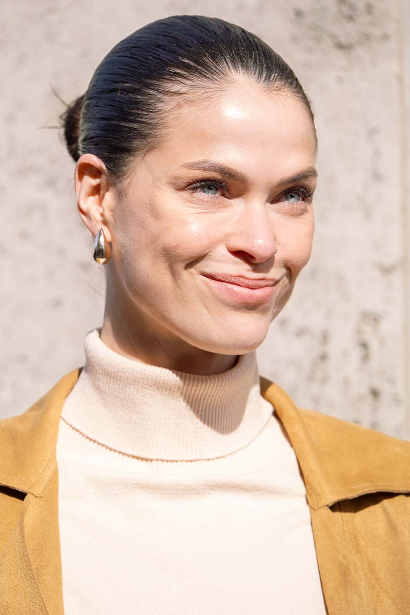 Glad naar achteren gekamd haar met glanzend haarproduct en strakke knot. Foto Charlotte Mesman
