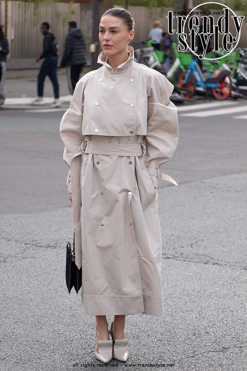 Genodigde bij Paris Fashion Week in een lange lichte trench coat, gestyled met elegante couture hakken voor een verfijnde streetstyle look. Foto Charlotte Mesman
