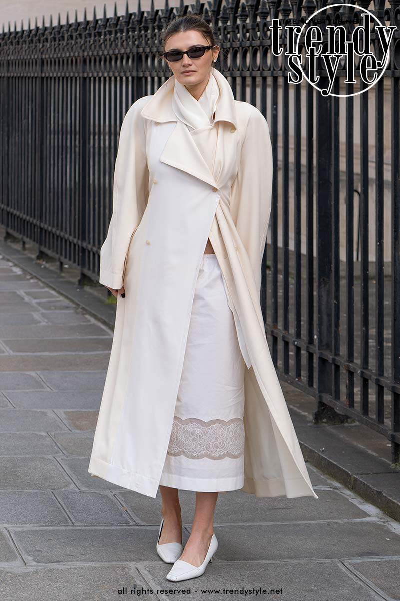 Superchique lichte trench coat over lange witte rok met witte pumps met kitten heels. Foto Charlotte Mesman