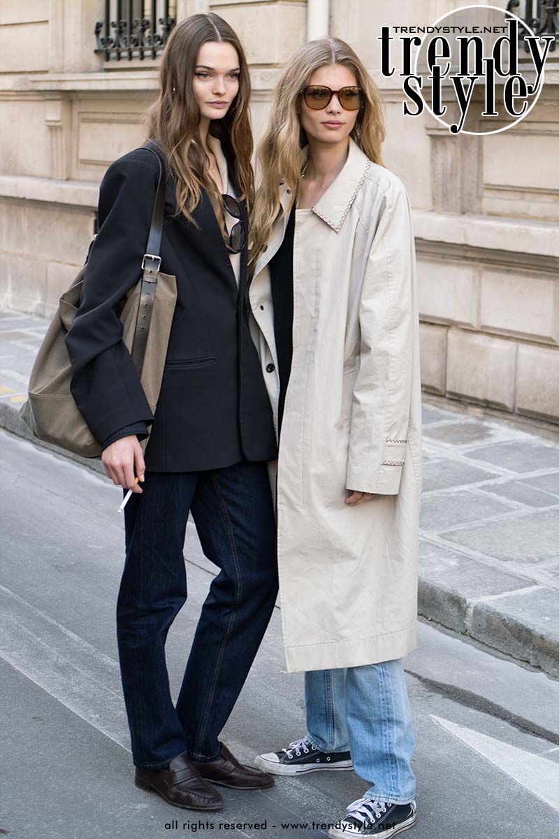 Model Ida Heiner (rechts) in een oversized trench coat met spijkerbroek en All Stars voor een jonge en trendy look. Foto Charlotte Mesman
