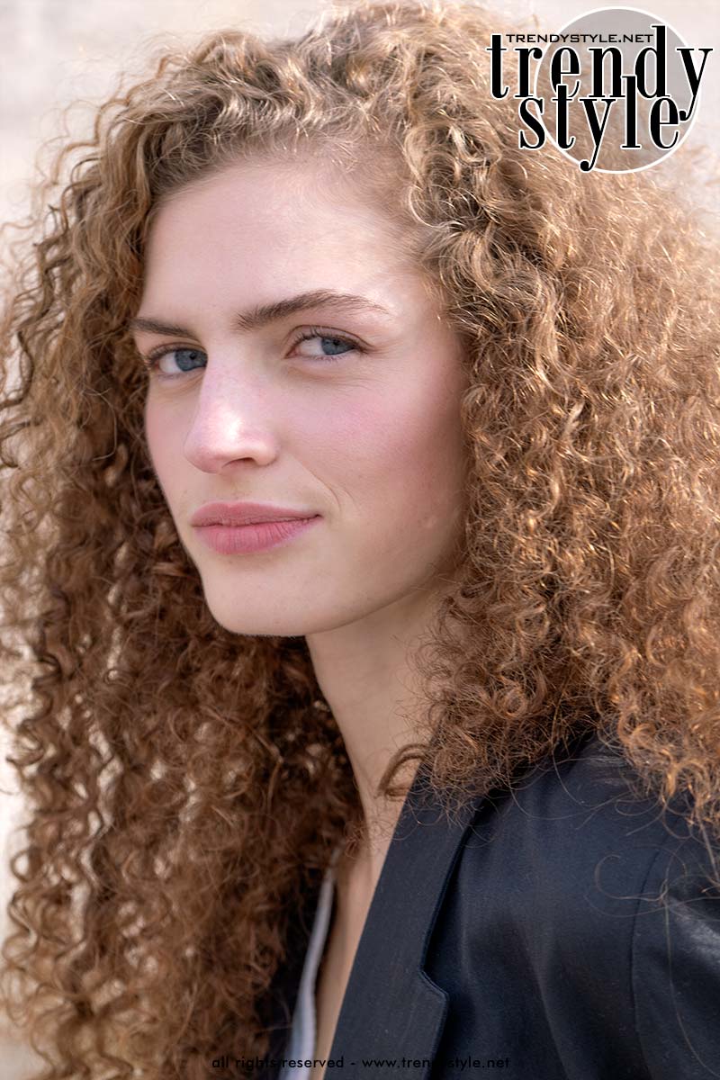 Streetstyle na Dior SS26: model met licht gekrulde ghost lashes, natuurlijke huid en effortless beautylook bij de showlocatie. Foto Charlotte Mesman