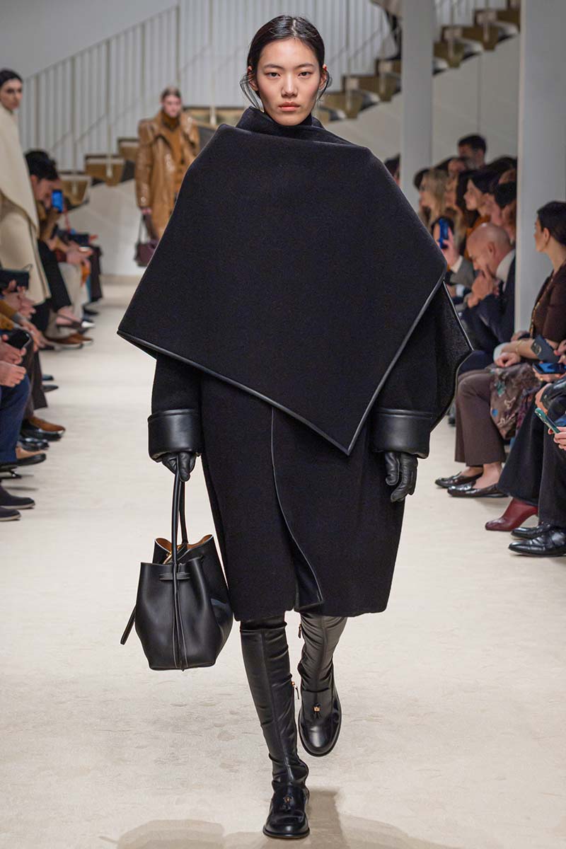 Hoge laarzen completeren deze total black look. Photo courtesy of Tod's