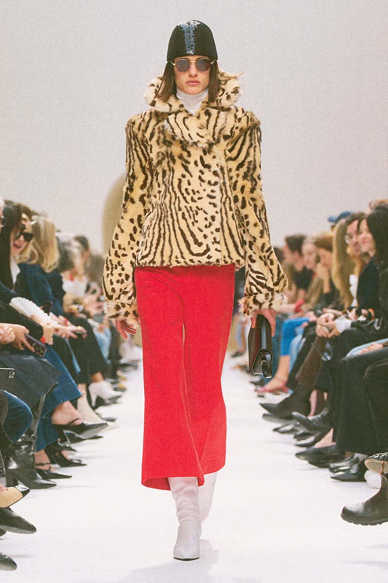 Een jasje in tijgerprints in combinatie met een rode broek en witte laarzen bij Celine. Photo courtesy of Celine