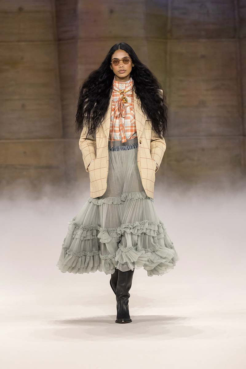 blazer met Prince of Wales-ruit, een tartan blouse of sjaal en een romantische crèmekleurige jurk met ruches, herfst/winter 2026-2027. Photo courtesy of Chloé