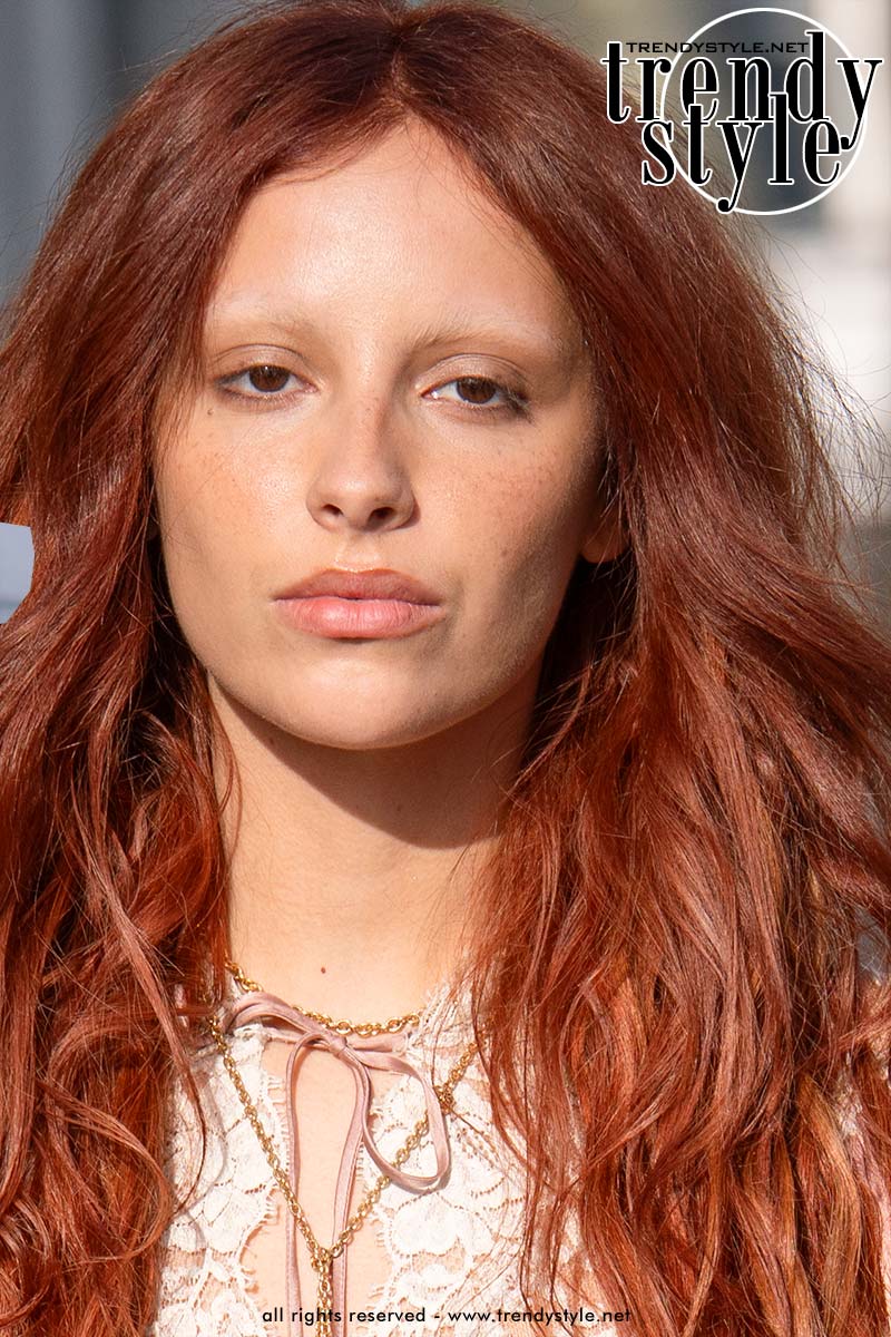 Influencer Marie Gaguech tijdens Paris Fashion Week met gebleekte wenkbrauwen als signatuurlook in combinatie met felrood haar. Foto Charlotte Mesman