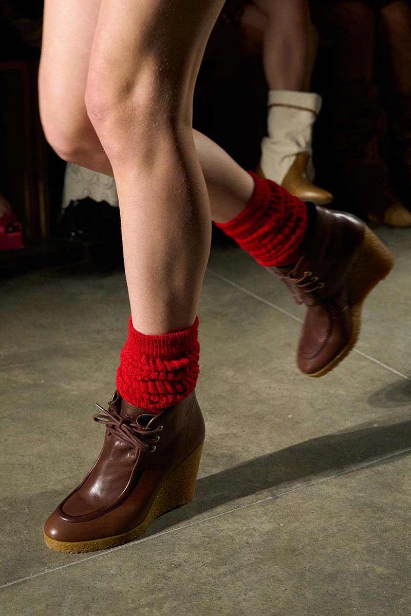 Blote benen met rode ribgebreide sokken en bruine veterlaarzen op de catwalk van Isabel Marant. Photo courtesy of Isabel Marant