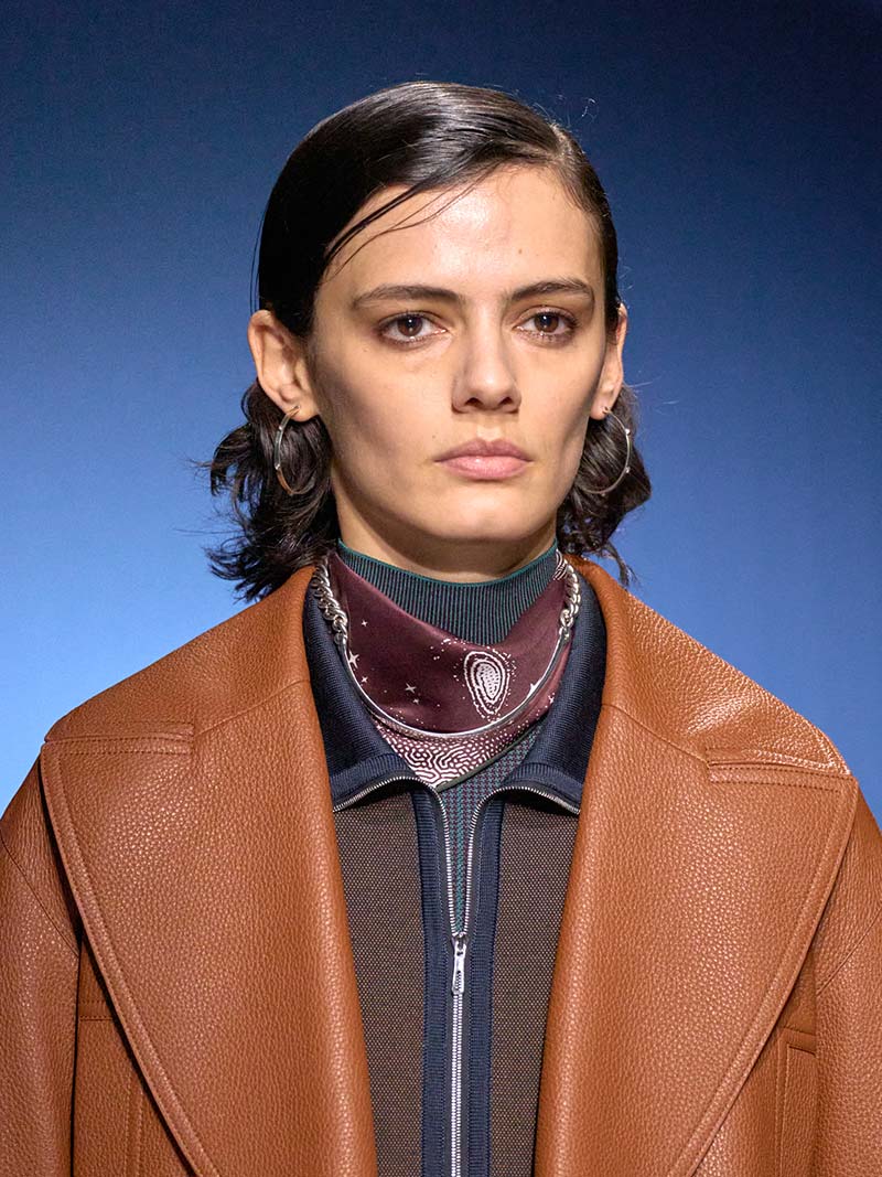 Verfijnde metalen ringen in contrast met fijnleren outfits bij Hermès. Photo courtesy of Hermès