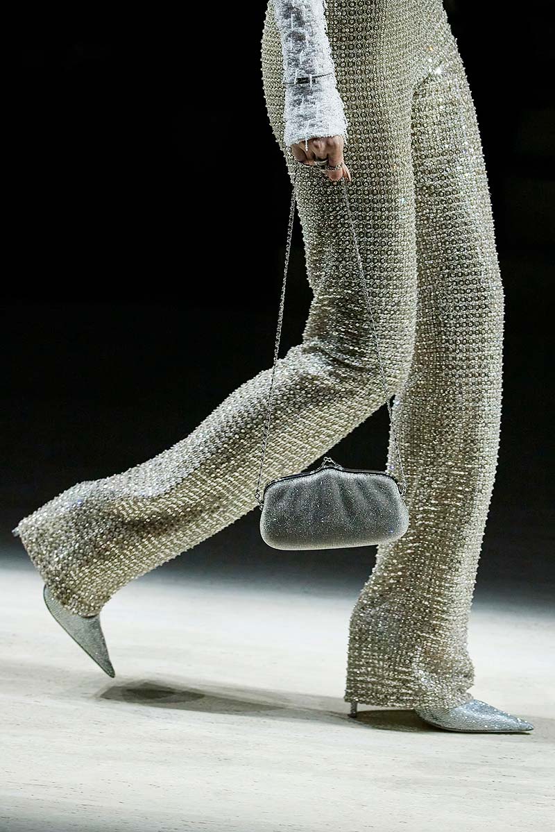 Metallic pumps onder een metallic broek met uitlopende pijpen bij Gucci. Pumps en tas zijn op elkaar afgestemd. Photo courtesy of Gucci