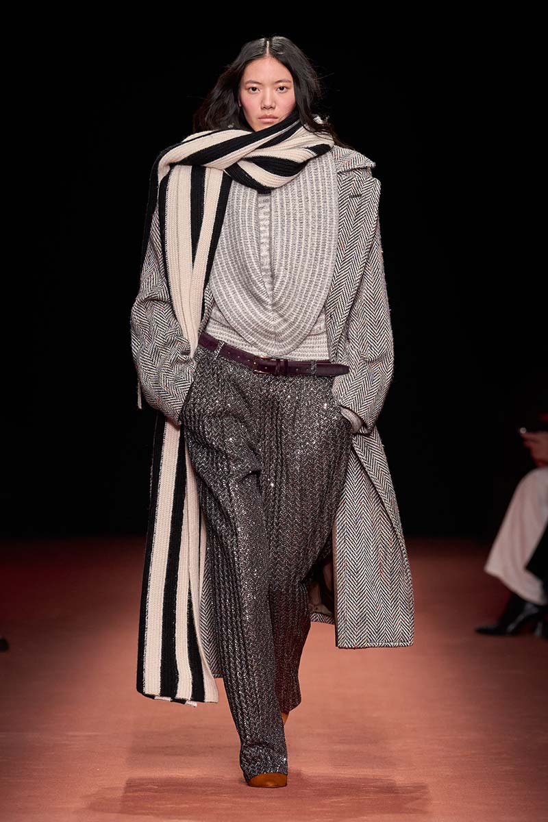 Oversized visgraatjas met royale trui, wijde broek en grote beige sjaal met zwart streeppatroon. Photo courtesy of Missoni
