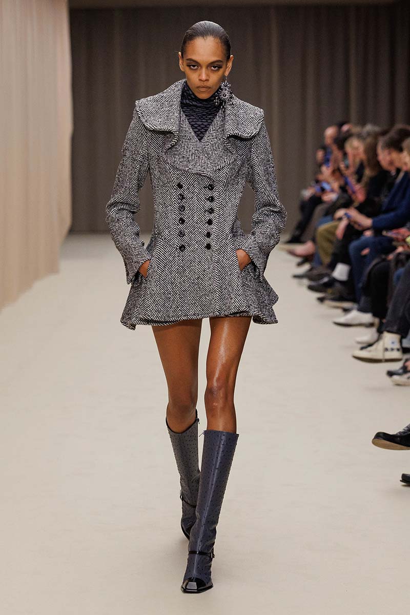 Getailleerde zwart-witte visgraatjas met dubbele rij knopen, sculpturale kraag en uitstaand schootje. Photo courtesy of Alexander McQueen