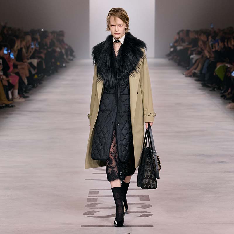 Zwarte puffer onder een beige trenchcoat met zwarte bontkraag op de catwalk van Fendi voor herfst winter 2026 2027. Photo courtesy of Fendi