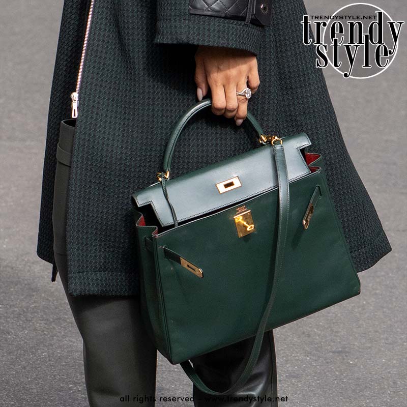 Hermès Kelly tas, hier met de afneembare schouderriem eraan. Donkergroen leer met goudkleurig beslag. Je ziet duidelijk de trapeziumvorm en de Kelly-sluiting. Foto Charlotte Mesman