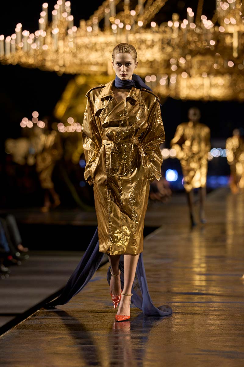 Goudkleurige trenchcoat met hoog eyecatcher gehalte bij Yves Saint Laurent. Photo courtesy of YSL