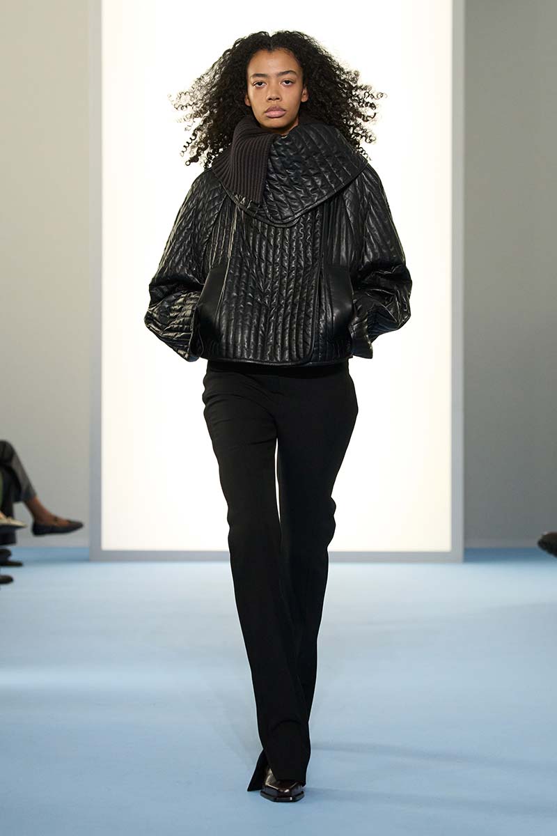 Kort zwart pufferjack op zwarte slim fit broek bij Sportmax voor een moderne look. Photo courtesy of Sportmax