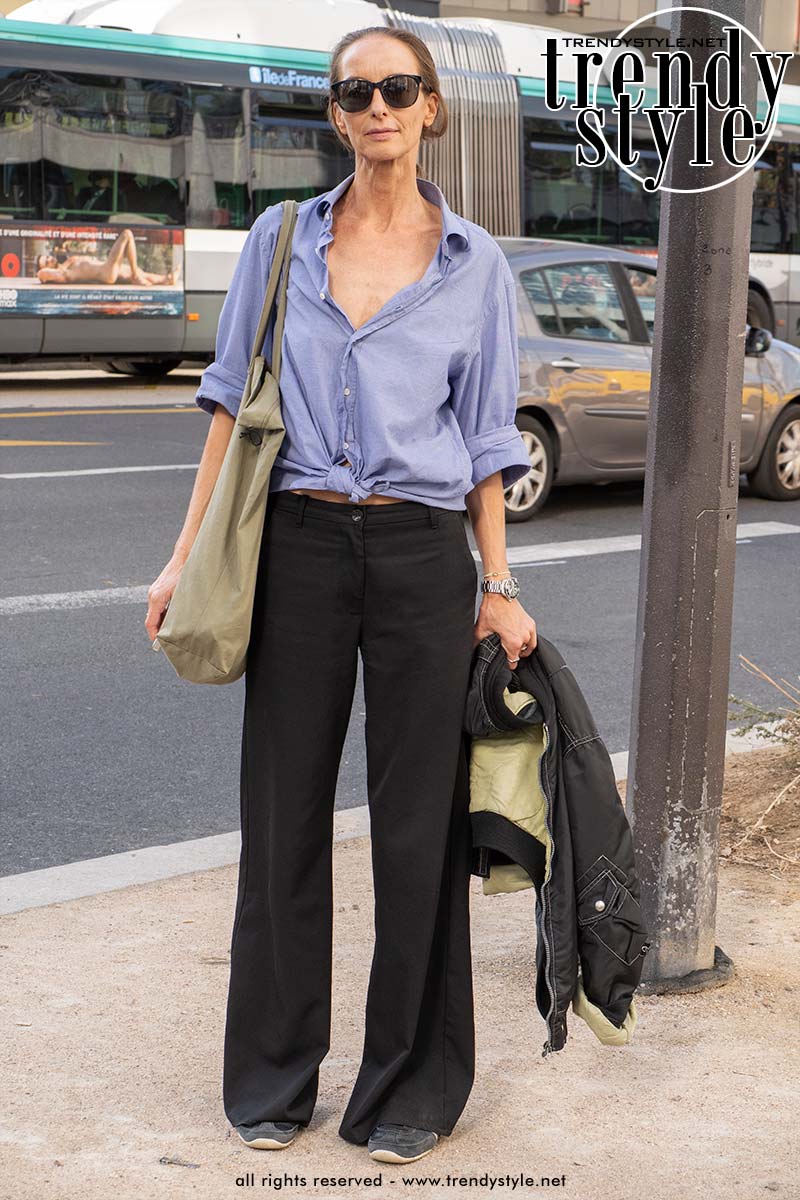 Model Dörte Kleihauer in lichtblauw overhemd met knoop, zwarte wide leg broek en sneakers tijdens de Paris Fashion Week. Foto Charlotte Mesman