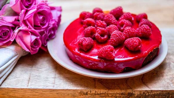 Valentijnsrecept. Chocoladetaart met rood spiegelglazuur en frambozen. Foto: Charlotte Mesman