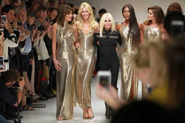 De Super Models van toen op de catwalk van Versace zomer 2018. Van links naar rechts: Helena Christensen, Claudia Schiffer, Donatella Versace, Naomi Campbell, Cindy Crawford, Carla Bruni